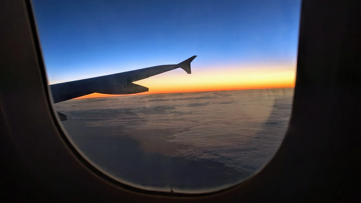 Flying with cremated ashes: looking out at airplane wing at sunset